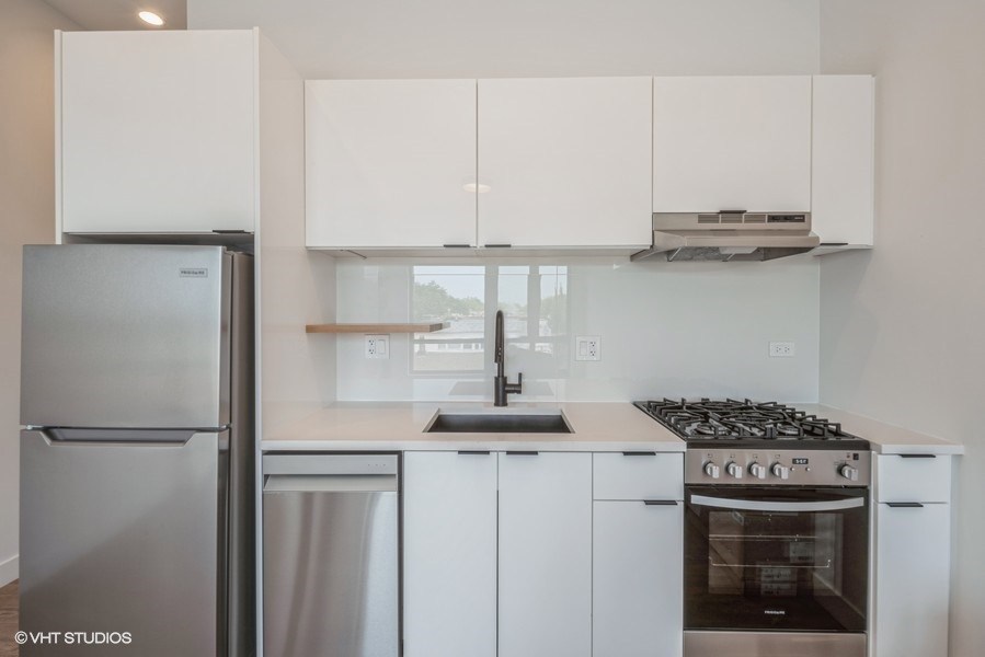 a kitchen with white cabinets and stainless steel appliances